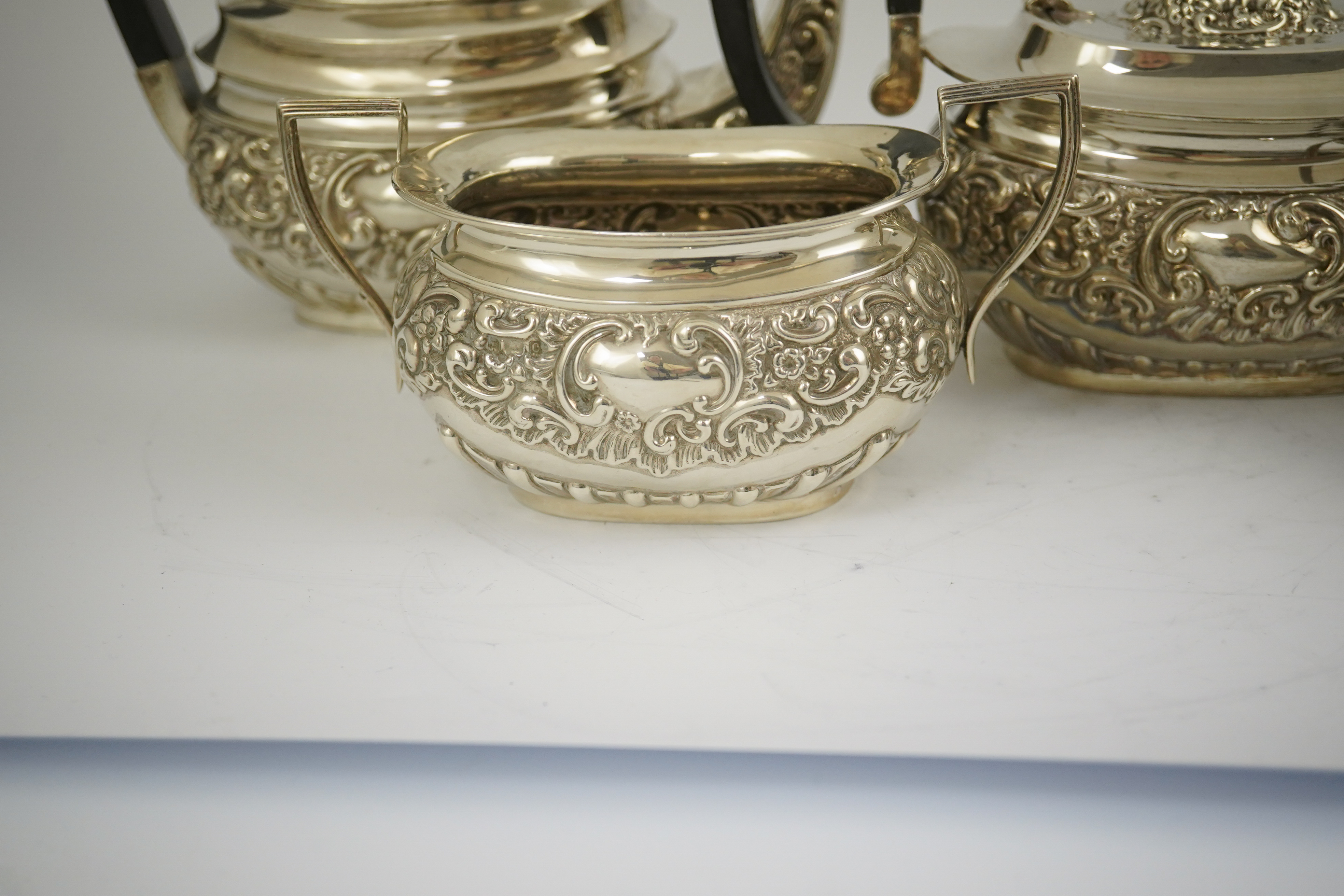 An Edwardian embossed silver four piece tea and coffee set, by S. Glass